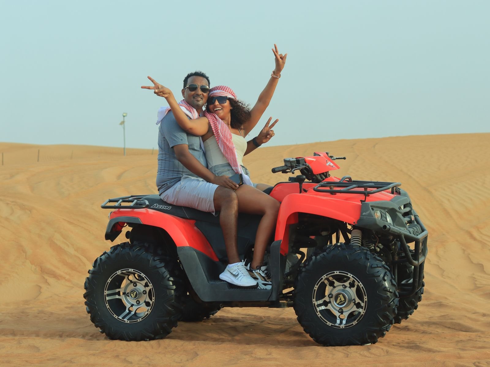 Couple riding a quad bike on a desert safari