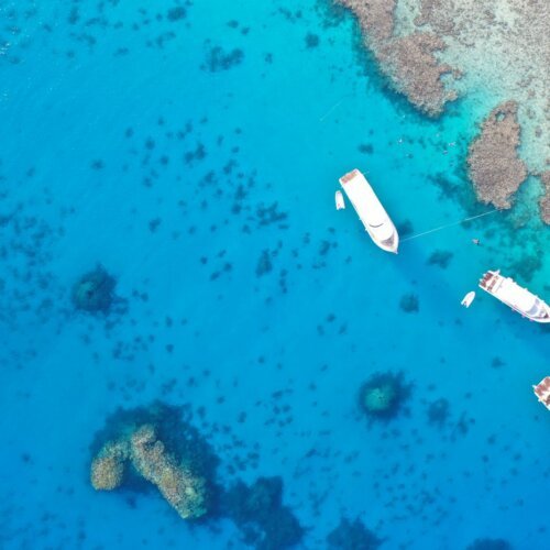 Boats moored near coral reefs in the clear water of the Red Sea, Hurghada