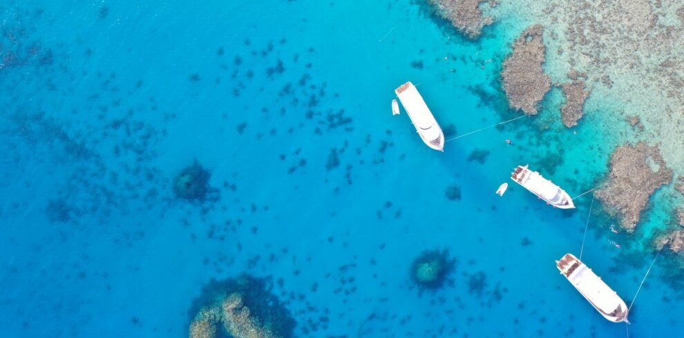 Boats moored near coral reefs in the clear water of the Red Sea, Hurghada