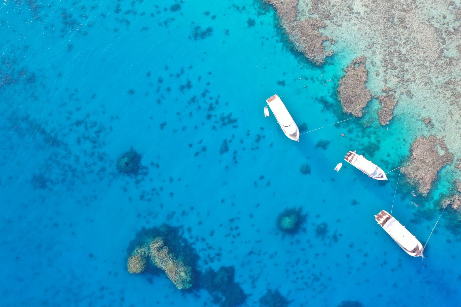 Boats moored near coral reefs in the clear water of the Red Sea, Hurghada