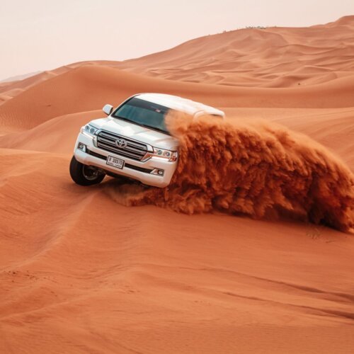 4x4 jeep driving over sand dunes on a desert safari