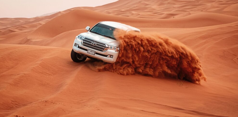 4x4 jeep driving over sand dunes on a desert safari