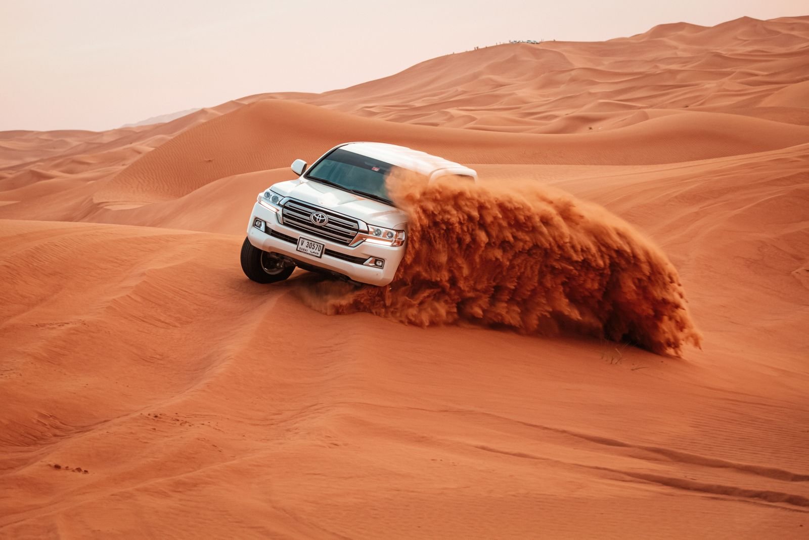 4x4 jeep driving over sand dunes on a desert safari